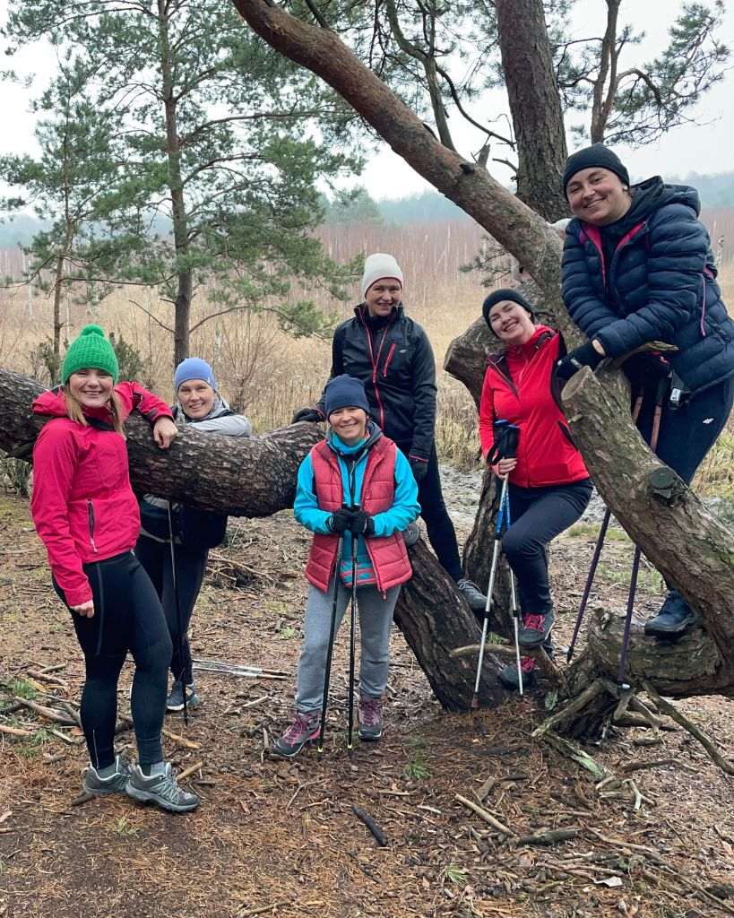 Grupa uczestników wycieczki nordic walking w Kampinoskim Parku Narodowym podczas aktywnej wyprawy z przewodnikiem.