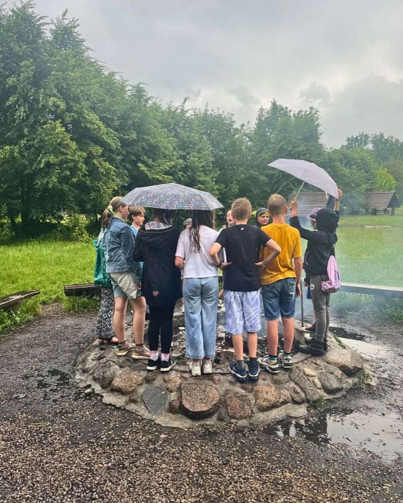 Grupa młodzieży podczas wycieczki szkolnej bawi się na Polanie Opaleń w Kampinoskim Parku Narodowym.